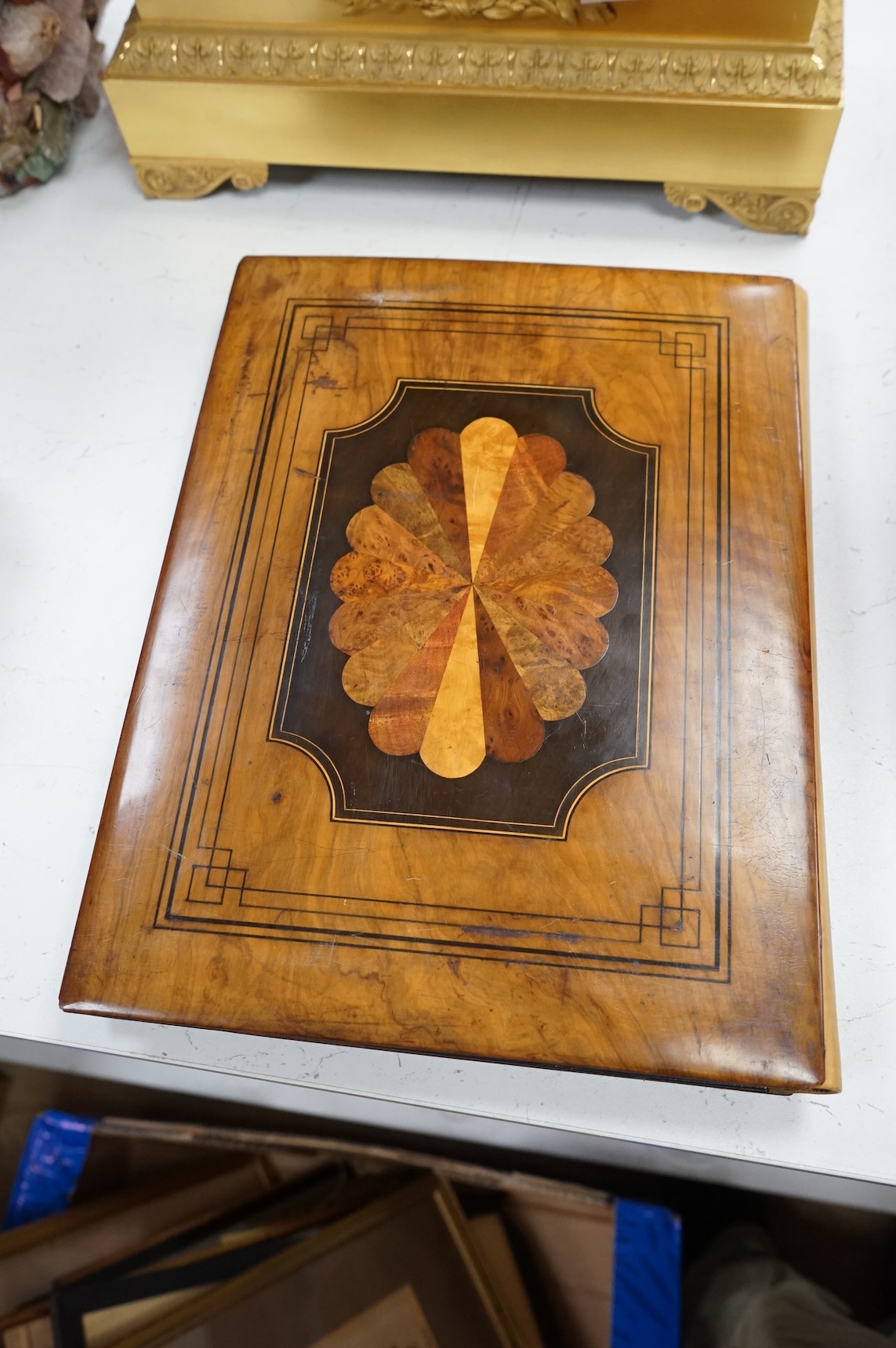 An olive and marquetry desk blotter, Duke of Wellington on horseback and his coat of arms, together with a cloth and gilt book, Army and Navy Drolleries by Captain Seccombe
